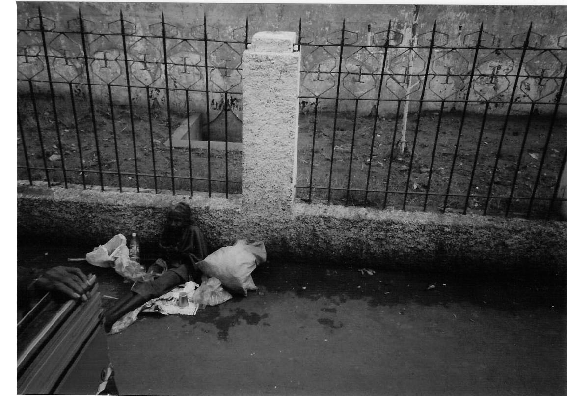 Bejaarde vrouw in de goot